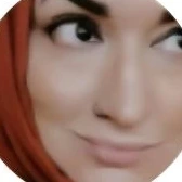 Portrait of Essma smiling, wearing an orange hijab.